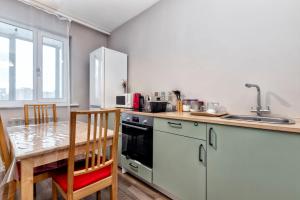 una cucina con tavolo, lavandino e piano cottura di Уютные апартаменты в Астане a Astana