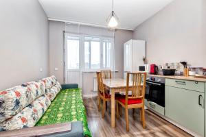 un soggiorno con un divano e un tavolo con sedie di Уютные апартаменты в Астане a Astana