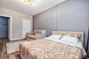 una camera da letto con un letto grande e una sedia di Уютные апартаменты в Астане a Astana Altre 4 foto