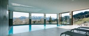 a house with a swimming pool with a view of mountains at Panoramahotel Kühbergalp in Gunzesried