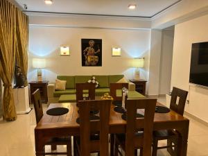 a living room with a table and a green couch at Anna Asia Villa in Kandy