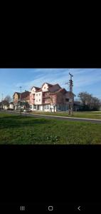 a large building in front of a field of grass at Small cute doublebed room A4 in Pančevo in Pančevo