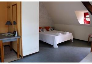a bedroom with a white bed and a table at Domaine du Rougier in Camarès