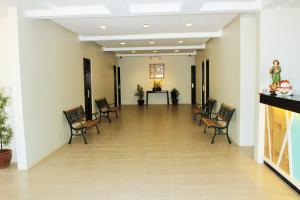 um corredor com cadeiras e uma mesa num edifício em Coron Visitors Hotel em Coron