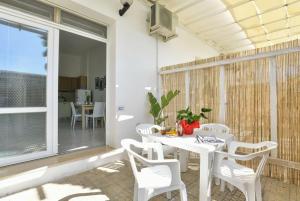 a patio with a white table and chairs and a balcony at Residence Baia D'Oro in Torre Mozza