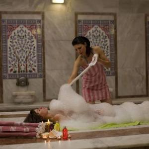 a woman is washing a woman in a bath tub at Turkishbath spa wellnes in Fethiye
