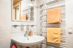 a bathroom with a sink and a mirror and towels at Voglbach, Bauernhof in Rauris +50 photos