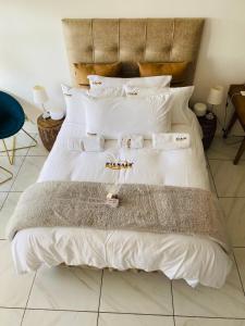 a bedroom with a bed with white sheets and pillows at Brookes Hill Private Suite in Port Elizabeth +10 photos