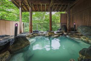 a pool of water with rocks in a house at Onsen & Stay OAKHILL in Zao Onsen +71 photos
