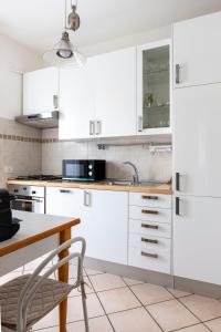 a kitchen with white cabinets and a sink and a table at Da Carla - alle porte di Roma in Settebagni +18 photos