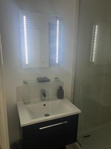 Un baño blanco con lavabo y espejo. en NiCheGetaway, en Shrewsbury 18 fotos más