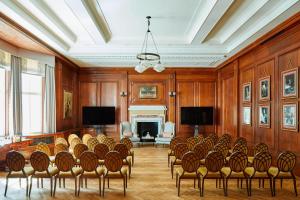 a room with a bunch of chairs and a fireplace at London Marriott Hotel County Hall in London