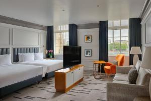 a hotel room with two beds and a flat screen tv at London Marriott Hotel County Hall in London