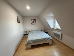 a attic bedroom with a bed and a window at Tranquillité in Rountzenheim