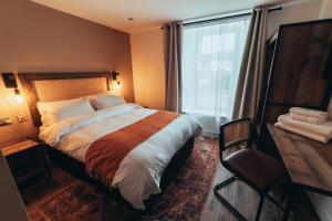 a bedroom with a large bed and a window at The Kings Head, Usk in Usk
