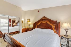 a bedroom with a large bed with a wooden headboard at Grand Wood Suites - 3rd Floor Front Side Corner Penthouse Suite 304 in Nashville