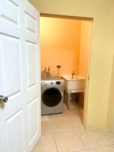 a bathroom with a washing machine and a sink at Cozy one bedroom apartment pool side in Lambeau