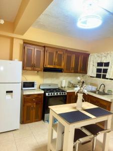 a kitchen with wooden cabinets and a white refrigerator at Cozy one bedroom apartment pool side in Lambeau