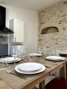 Una mesa de madera con platos y copas de vino encima. en Charme Thoiry-Versailles-Giverny, en Arnouville-lès-Mantes 21 fotos más