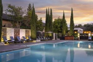 ナパにあるNapa Valley Marriott Hotel & Spaのラウンジチェアと木々のあるプール