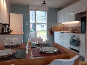 a kitchen with a table with plates and glasses on it at Maison au calme idéale pour découvrir Sud Finistère in Quimper