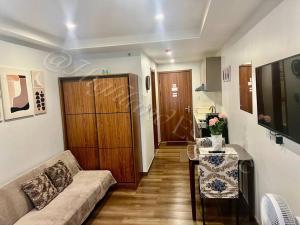 a living room with a couch and a table at 'Highland Escape' Condo Studio Unit in Baguio