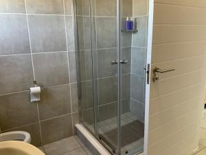 a shower with a glass door in a bathroom at Cozy nest apartment in Pretoria +15 photos