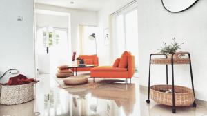 a living room with an orange chair and a table at Villa LA Lembang Retreat - Bed & Breakfast in Lembang