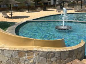 a fountain in the middle of a swimming pool at Cozy nest apartment in Pretoria