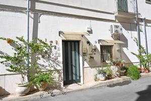 Un edificio bianco con una porta e alcune piante in vaso di Civico 1 a Oria