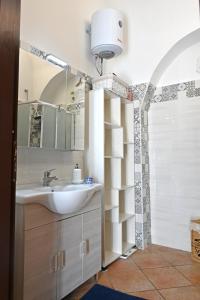 un bagno con lavandino, specchio e doccia di Civico 1 a Oria