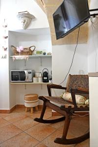 un soggiorno con sedia e TV a parete di Civico 1 a Oria
