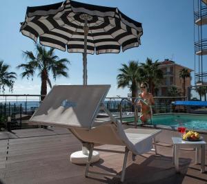 una silla y una sombrilla junto a una piscina en Hotel Lungomare, en Andora