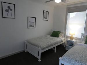 a white room with two beds and a window at Moonta Bay Stylish large home 3 min walk from beach and jetty in Port Moonta +54 photos