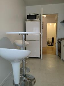 a kitchen with a white sink and a microwave at Les Lilas in Chantepie