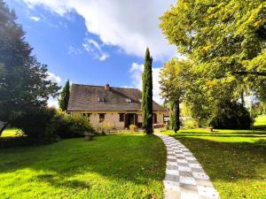 una casa con un camino de piedra delante de un patio en Cocon familial verdoyant - Famille Only - Fête interdite, en Montreuil-aux-Lions