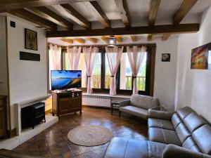 Una sala de estar con un sofá y un televisor de pantalla plana. en Cocon familial verdoyant - Famille Only - Fête interdite, en Montreuil-aux-Lions