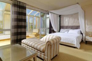 Un dormitorio con una cama con dosel y una silla. en Le Méridien Stuttgart, en Stuttgart