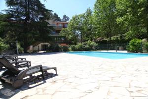 a patio with two benches and a swimming pool at Belle rivière en Cévennes in Corbés