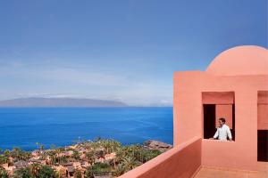 a man looking out of a window of a house at The Ritz-Carlton Tenerife, Abama in Guía de Isora