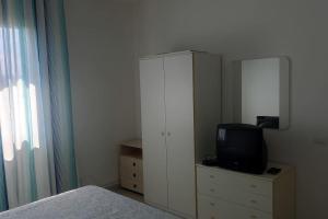 1 dormitorio con 1 cama y vestidor con TV en Villa Orione 2006, en Fontane Bianche