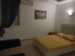 a bedroom with a bed and a picture on the wall at Villa el manzel in Fafou