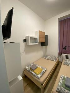 a small room with two beds and a tv at Red&Black Apartment City centr, Na Hradbách 118 in Ostrava