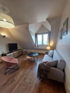 a living room with a couch and a table at Confort entre lac et montagne in Tresserves