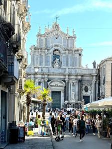 a large building with a clock tower in a street at Duomo View Apartment in Catania