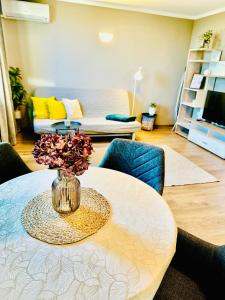 a table with a vase with flowers on it in a living room at PANORAMA APARTMENT in Montana