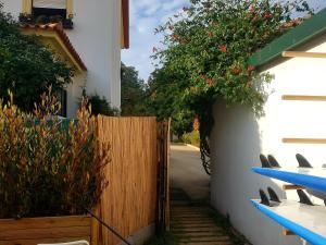 a wooden fence with a gate and a fence with surfboards at Conde Surf Camp - Capsule Beds FEMALE Dorm in Vila do Conde