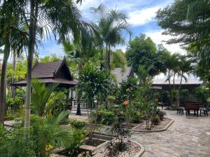 a garden with trees and plants in front of a building at Suanpai Resort Sattahip in Sattahip