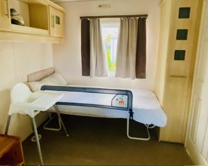 ein kleines Zimmer mit einem Bett und einem Fenster in der Unterkunft Ferienhaus Vienna am Kronensee in Ostercappeln