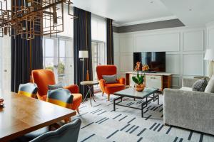a living room with orange chairs and a table at London Marriott Hotel County Hall in London
